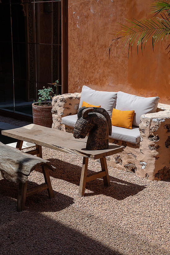 Riad courtyard, low arches, dappled light